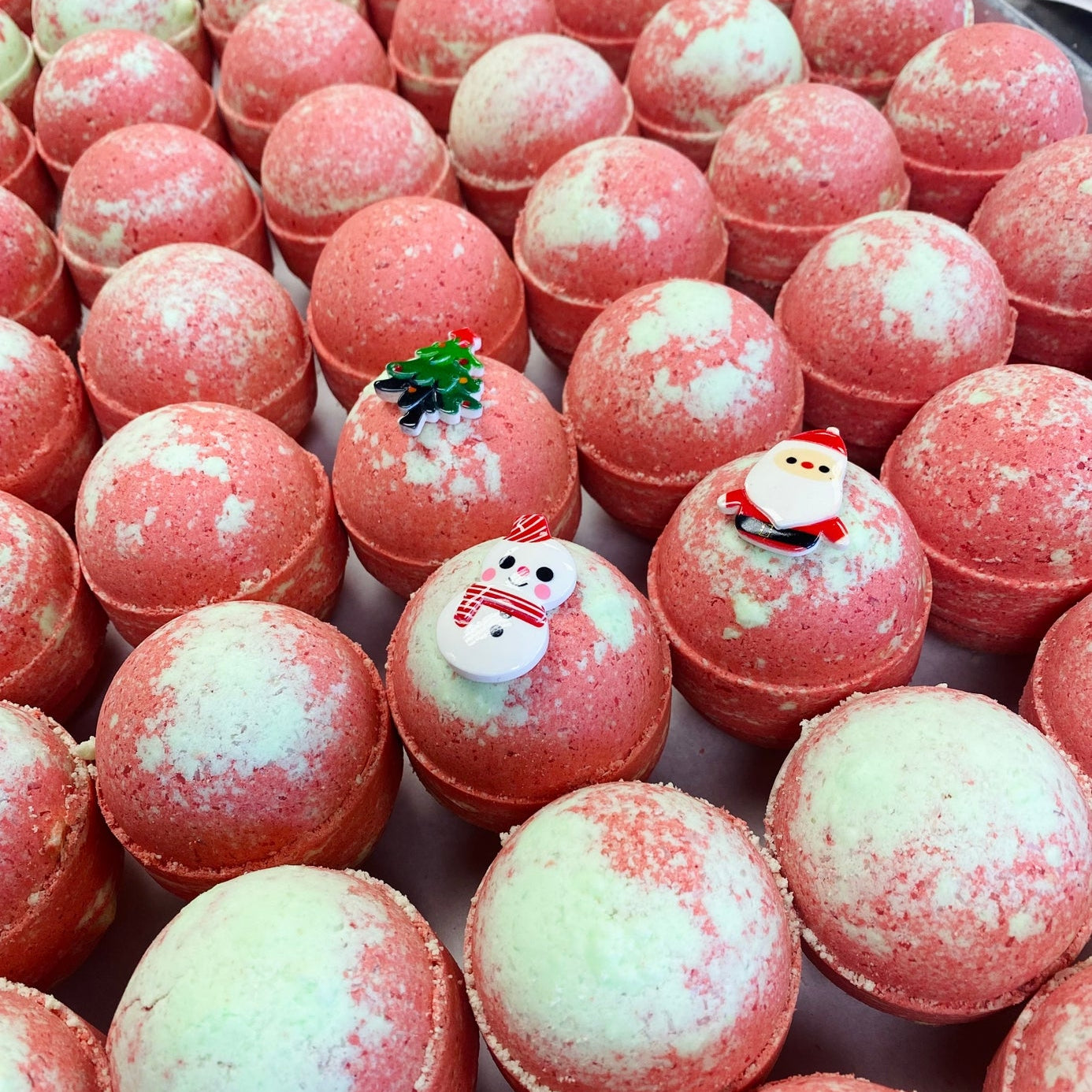 Bath bombs with decorative figures on a white surface