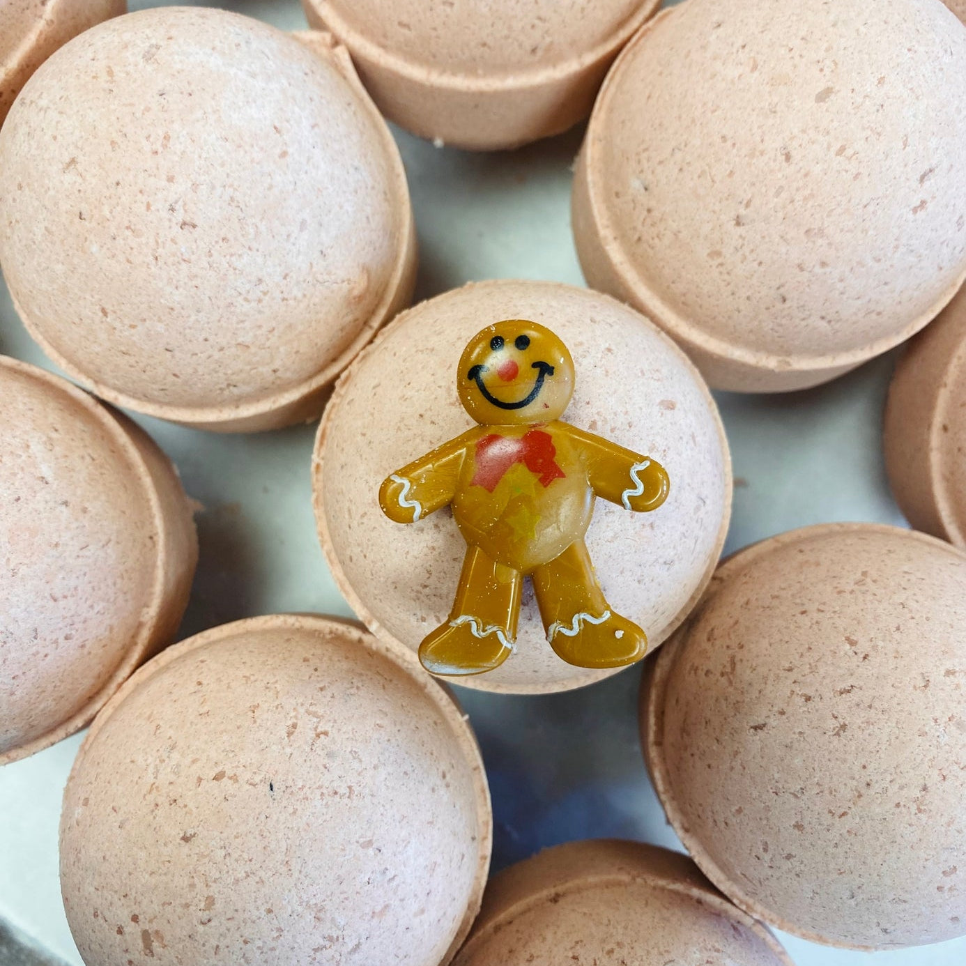 Bath bombs with a gingerbread man design on a light blue background