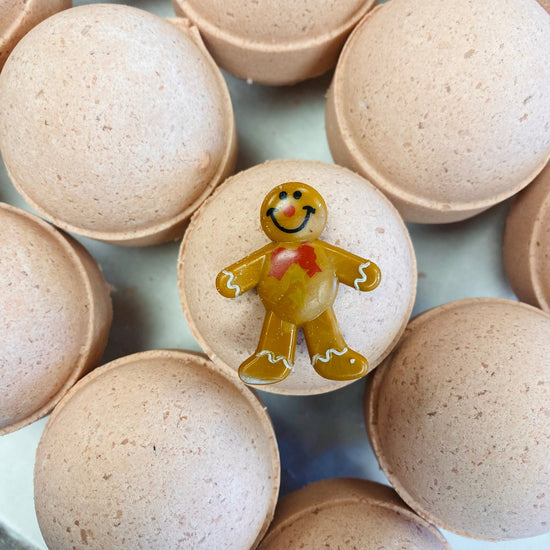 Bath bombs with a gingerbread man design on a light blue background