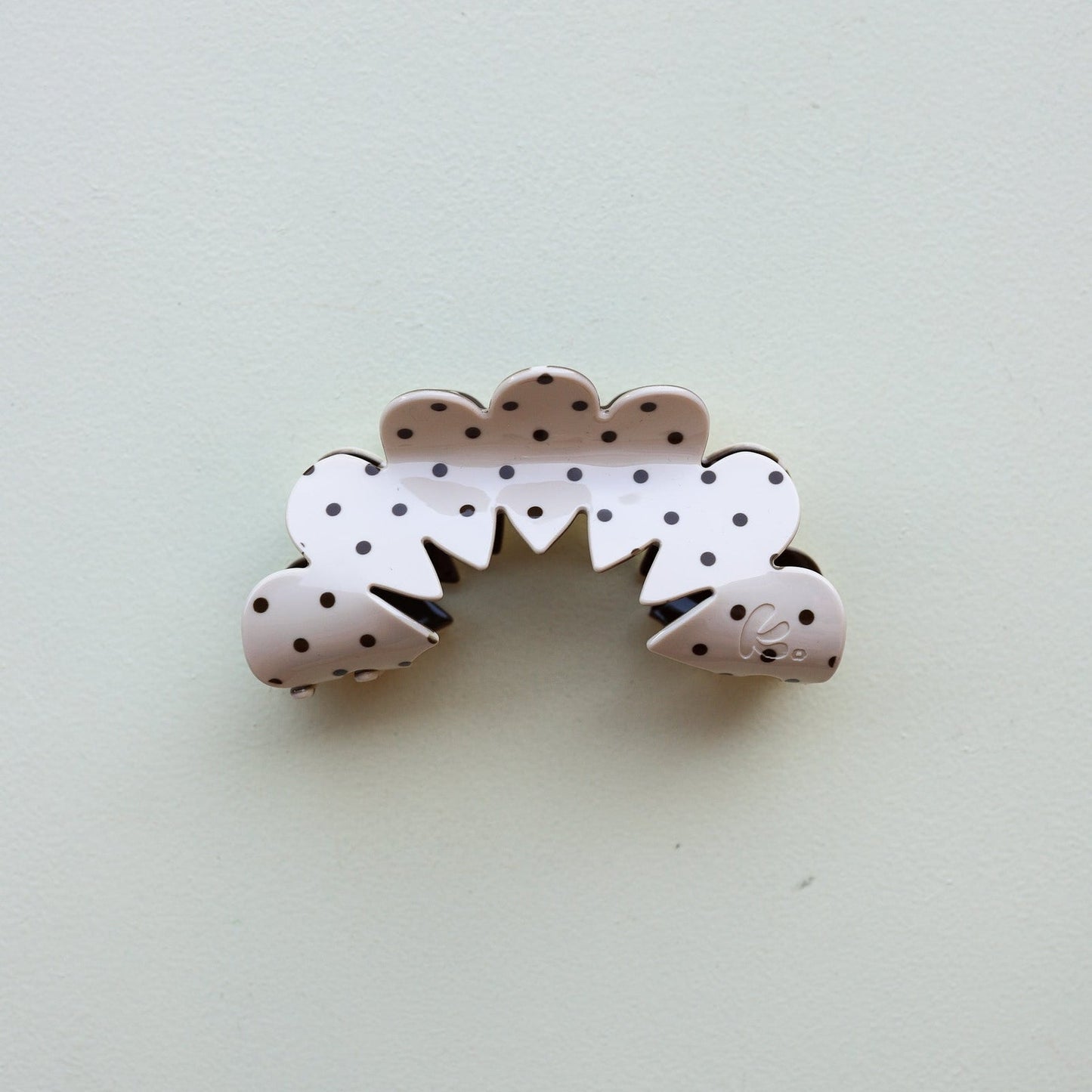 Decorative hair clip with polka dot design on a light gray background