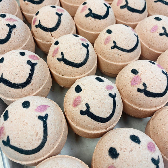 Bath bombs with smiley face designs on a tray