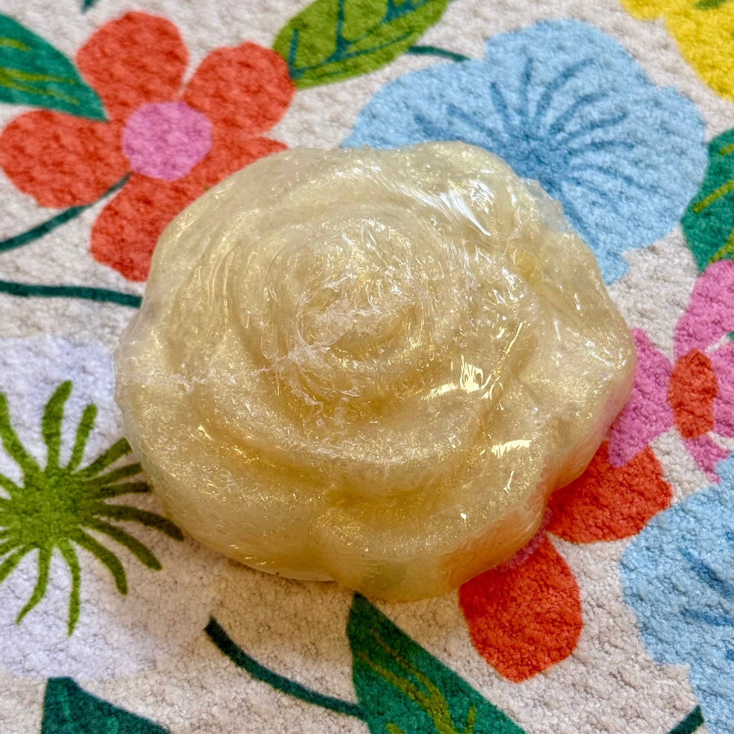 Rose-shaped bar of soap on a floral-patterned surface