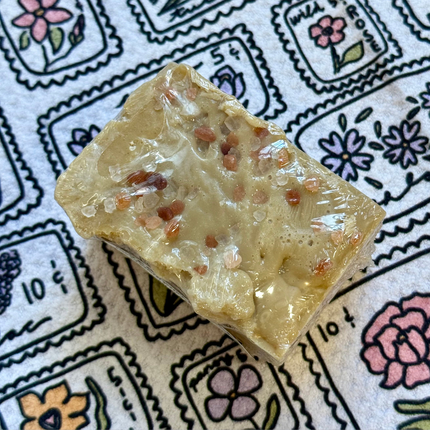 Bar of soap with visible ingredients on a patterned background