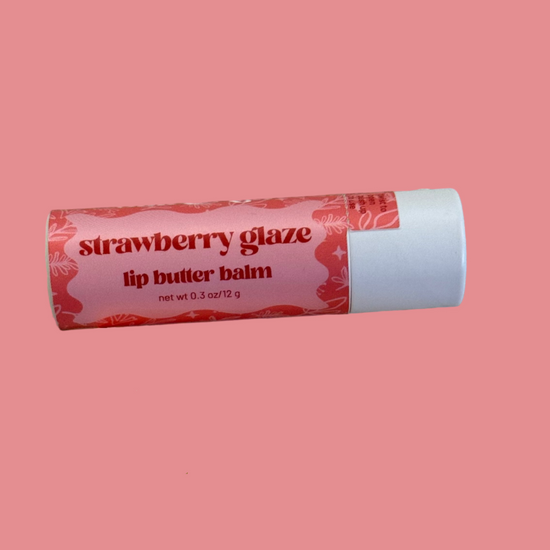 Two lip balm tubes, one strawberry glaze and one lemon loaf, on a pink background.