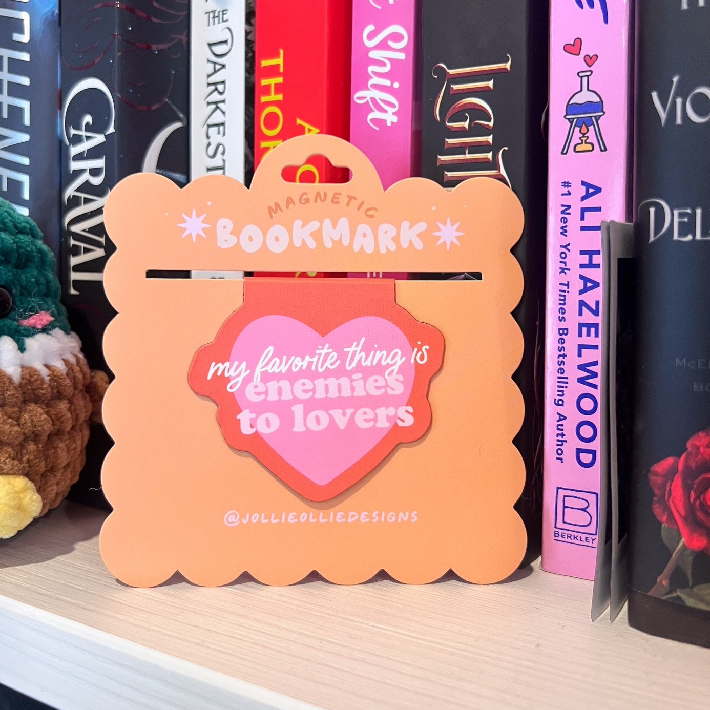 Orange magnetic bookmark with text on a bookshelf with books