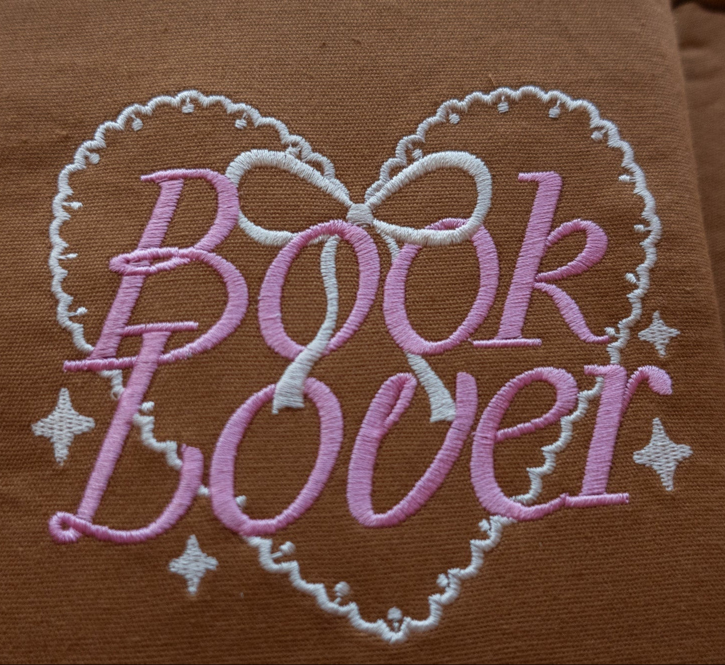Brown fabric book sleeve with 'Book Lover' embroidery in pink and white