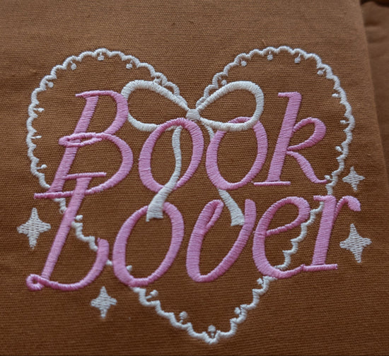 Brown fabric book sleeve with 'Book Lover' embroidery in pink and white